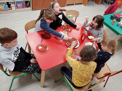Dzieci z Placówki Wsparcia Dziennego z Niemicy zajadają się kiełbaskami.