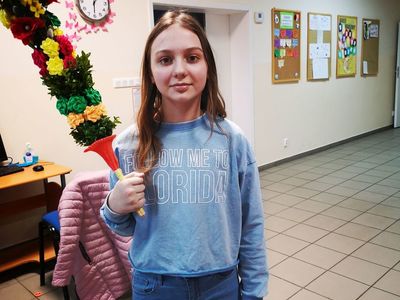 Dziecko z Placówki Wsparcia Dziennego w Pękaninie wraz z palmą, którą samodzielnie wykonała.