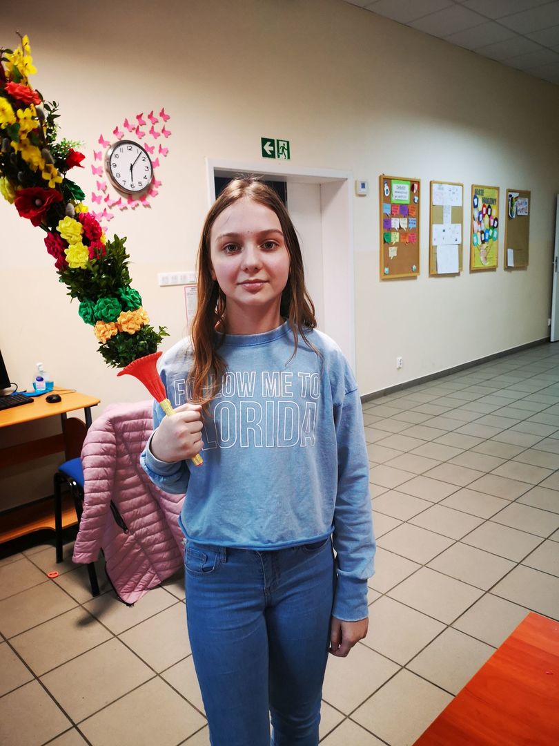 Dziecko z Placówki Wsparcia Dziennego w Pękaninie wraz z palmą, którą samodzielnie wykonała.