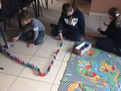 Trójka dzieci z Placówki Wsparcia Dziennego w Kosierzewie podczas gier w świetlicy.