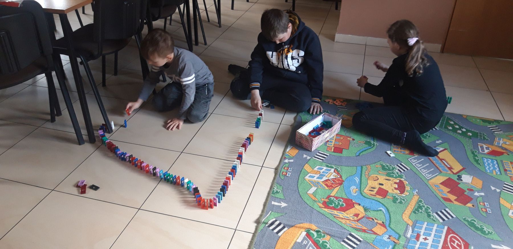 Trójka dzieci z Placówki Wsparcia Dziennego w Kosierzewie podczas gier w świetlicy.