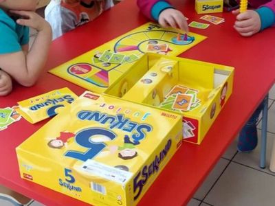 Dzieci z Placówki Wsparcia Dziennego w Laskach grające w grę planszową.

