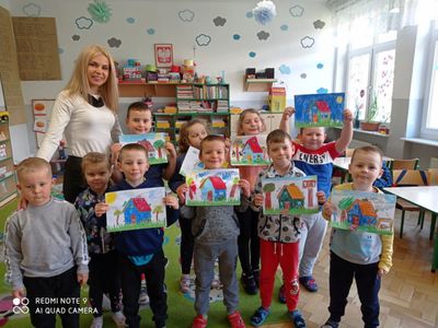 Wychowawczyni Marcjanna Malczewska i grupa przedszkolaków prezentująca swoje prace.