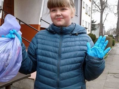 Uczennica z Zespołu Szkół im. Mikołaja Kopernika w Ostrowcu trzymająca worek, do którego zbiera śmieci.