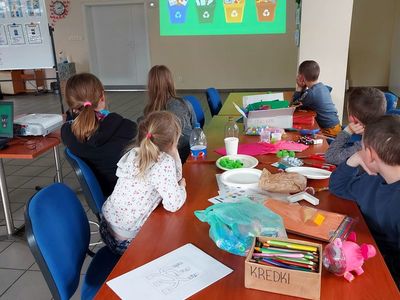 Podopieczni z Placówki Wsparcia Dziennego w Pękaninie w trakcie oglądania projekcji multimedialnej na temat recyklingu i ochronie Ziemi.
