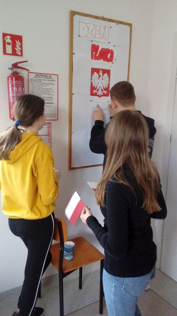 Dzieci z Placówki Wsparcia Dziennego w Ostrowcu przygotowujące gazetkę z okazji Dnia Flagi.
