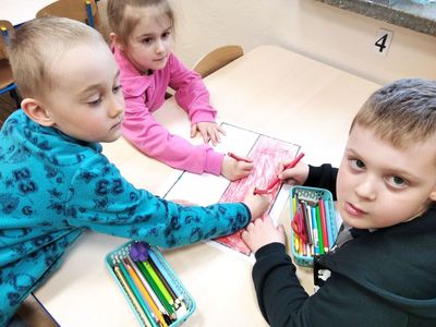 Dzieci z Zespołu Szkół im. Mikołaja Kopernika w Ostrowcu kolorują planszę w taki sposób, by powstała Flaga Polski.
