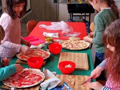Wychowankowie PWD w Niemicy nakładają na pizze swoje ulubione składniki.