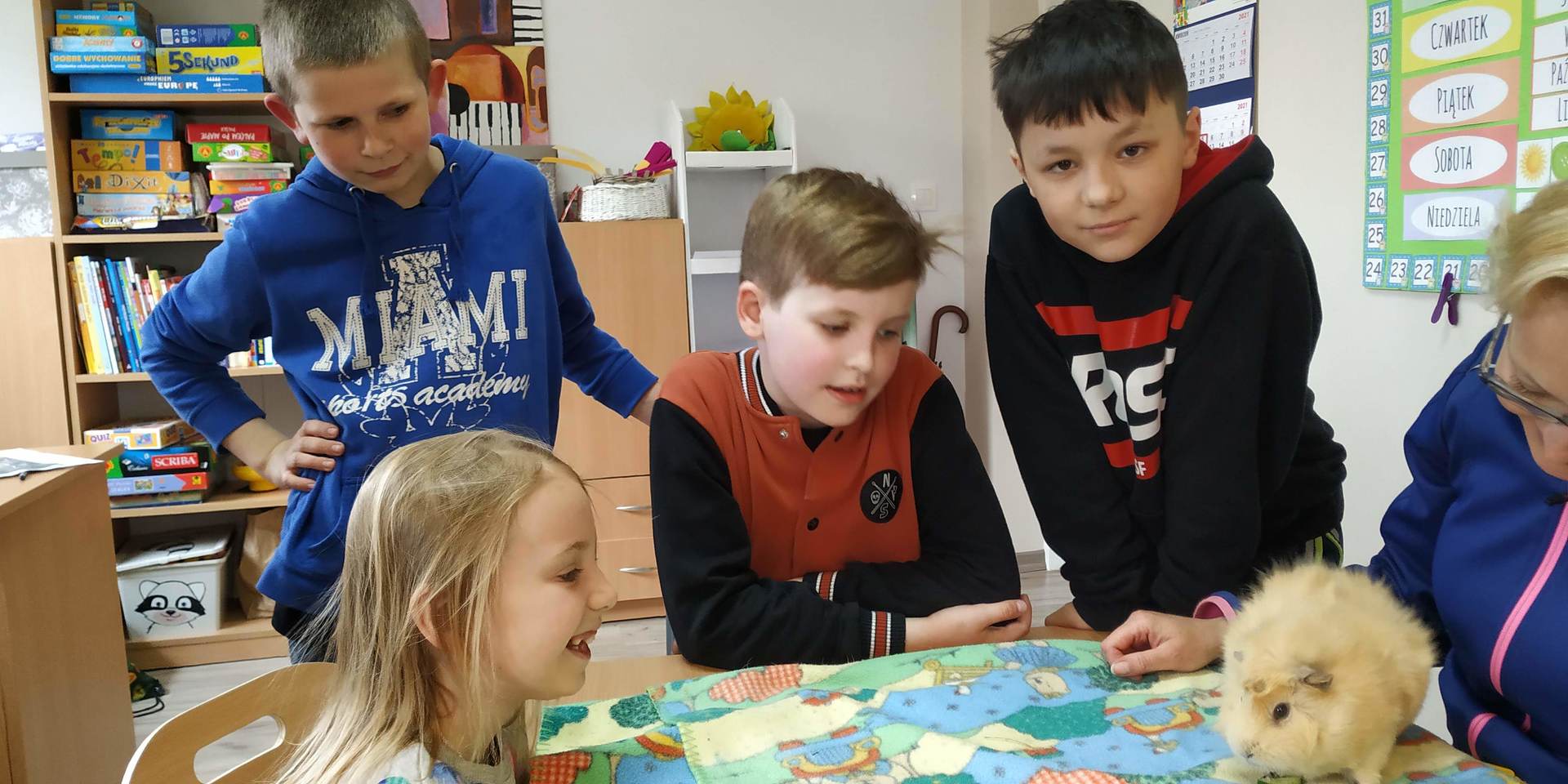 Wychowankowie PWD w Gorzycy zajmują się zwierzątkiem, które przyprowadzono w ramach Ogólnopolskiego Dnia Praw Zwierząt.