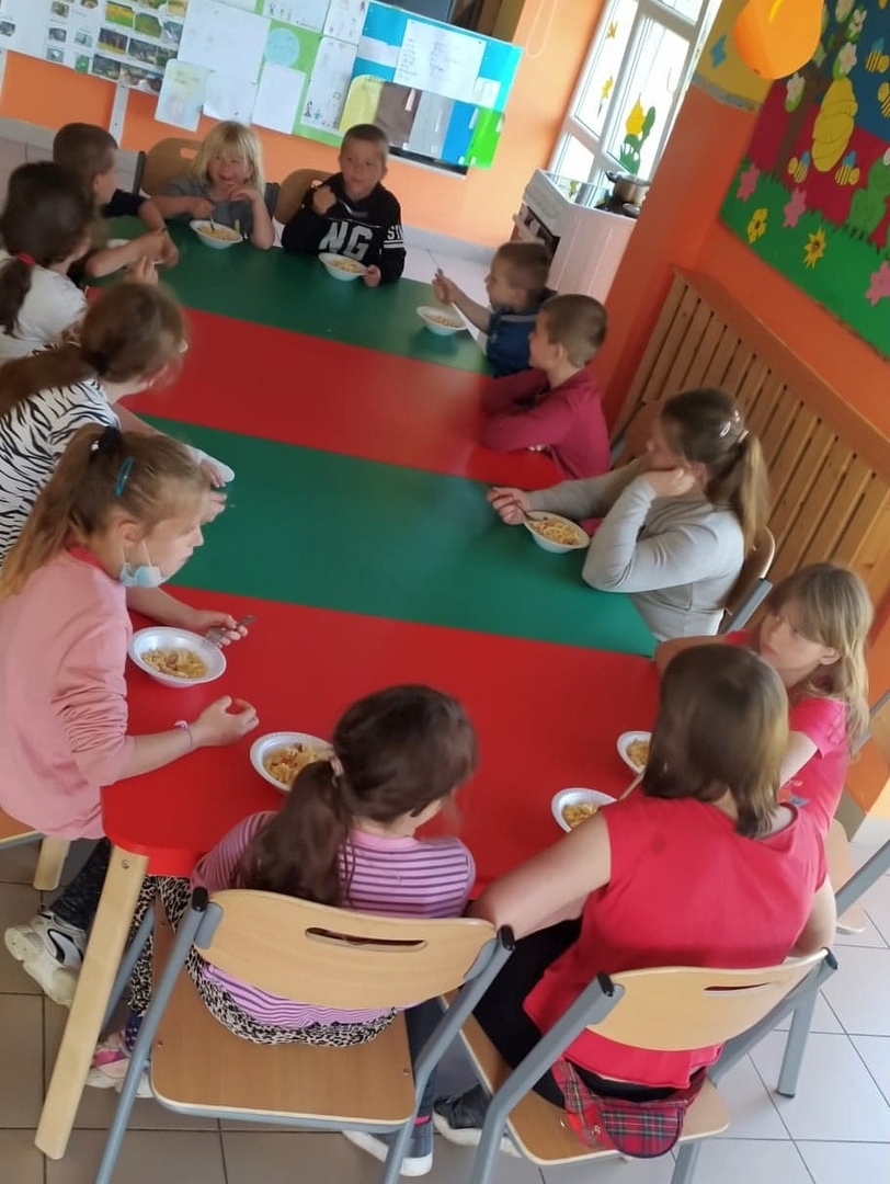 Zdjęcie przedstawia wychowanków jedzących sałatkę.