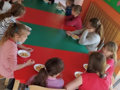 Zdjęcie przedstawia wychowanków jedzących sałatkę.