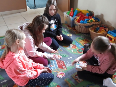 Zdjęcie przedstawia dzieci grające w UNO.