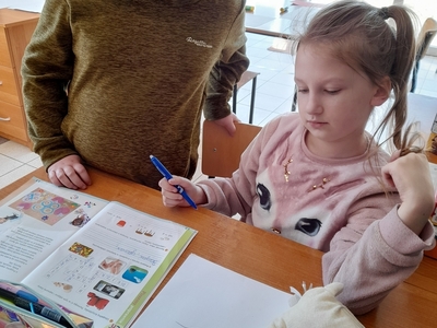 Zdjęcie przedstawia dwie dziewczynki z PWD w Sulechowie, podczas odrabiania lekcji.