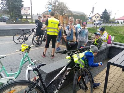 Dzieci z PWD Karwice przed sklepem w Malechowie w otoczeniu rowerów.