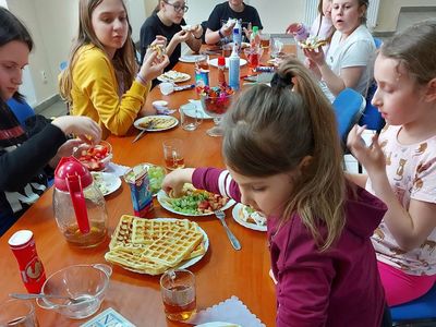 Podopieczni z  Placówki Wsparcia Dziennego w Pękaninie w trakcie degustacji przygotowanych przez siebie gofrów.