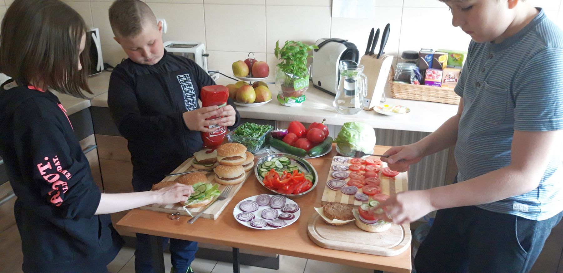Dziewczynki z Placówki Wsparcia Dziennego w Kosierzewie przygotowują hamburgery.

