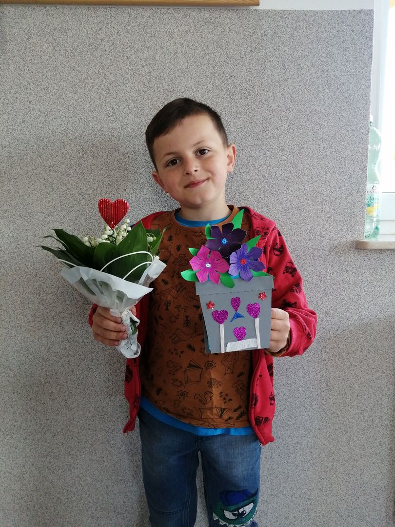 Wychowanek Placówki Wsparcia Dziennego w Kusicach z laurką na Dzień Mamy.