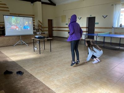 Dziewczynki z Placówki Wsparcia Dziennego ze Święcianowa w trakcie rywalizacji sportowej z wykorzystaniem konsoli do gier.