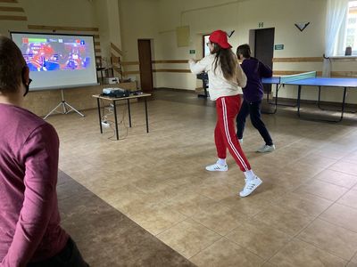 Dziewczynki z Placówki Wsparcia Dziennego ze Święcianowa w trakcie rywalizacji sportowej z wykorzystaniem konsoli do gier.