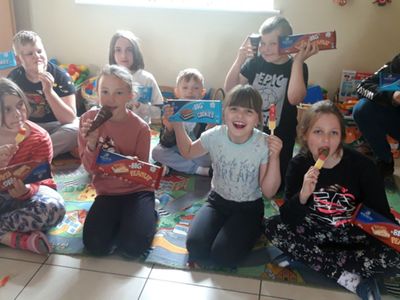 Grupa wychowanków z Placówki Wsparcia Dziennego w Kosierzewie ze słodkim poczęstunkiem w rączkach.