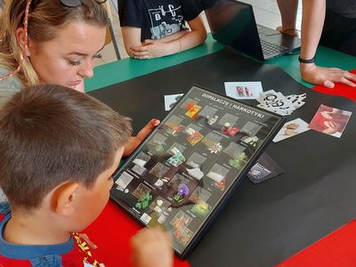 Dzieci z Placówki Wsparcia Dziennego w Laskach z wychowawczynią oglądające różne rodzaje dopalaczy.