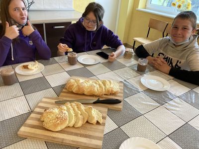 Uczestnicy zajęć kulinarnych z Placówki Wsparcia Dziennego w Święcianowie w trakcie degustacji wykonanych smakołyków.