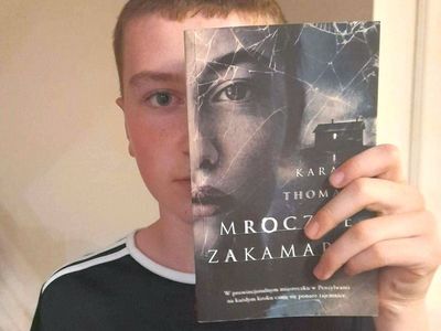 Uczeń ze Szkoły Podstawowej im. Noblistów Polskich w Niemicy wraz z książką w ramach akcji czytelniczej Sleeveface (Ubierz się w książkę).
