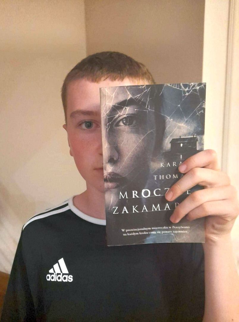 Uczeń ze Szkoły Podstawowej im. Noblistów Polskich w Niemicy wraz z książką w ramach akcji czytelniczej Sleeveface (Ubierz się w książkę).