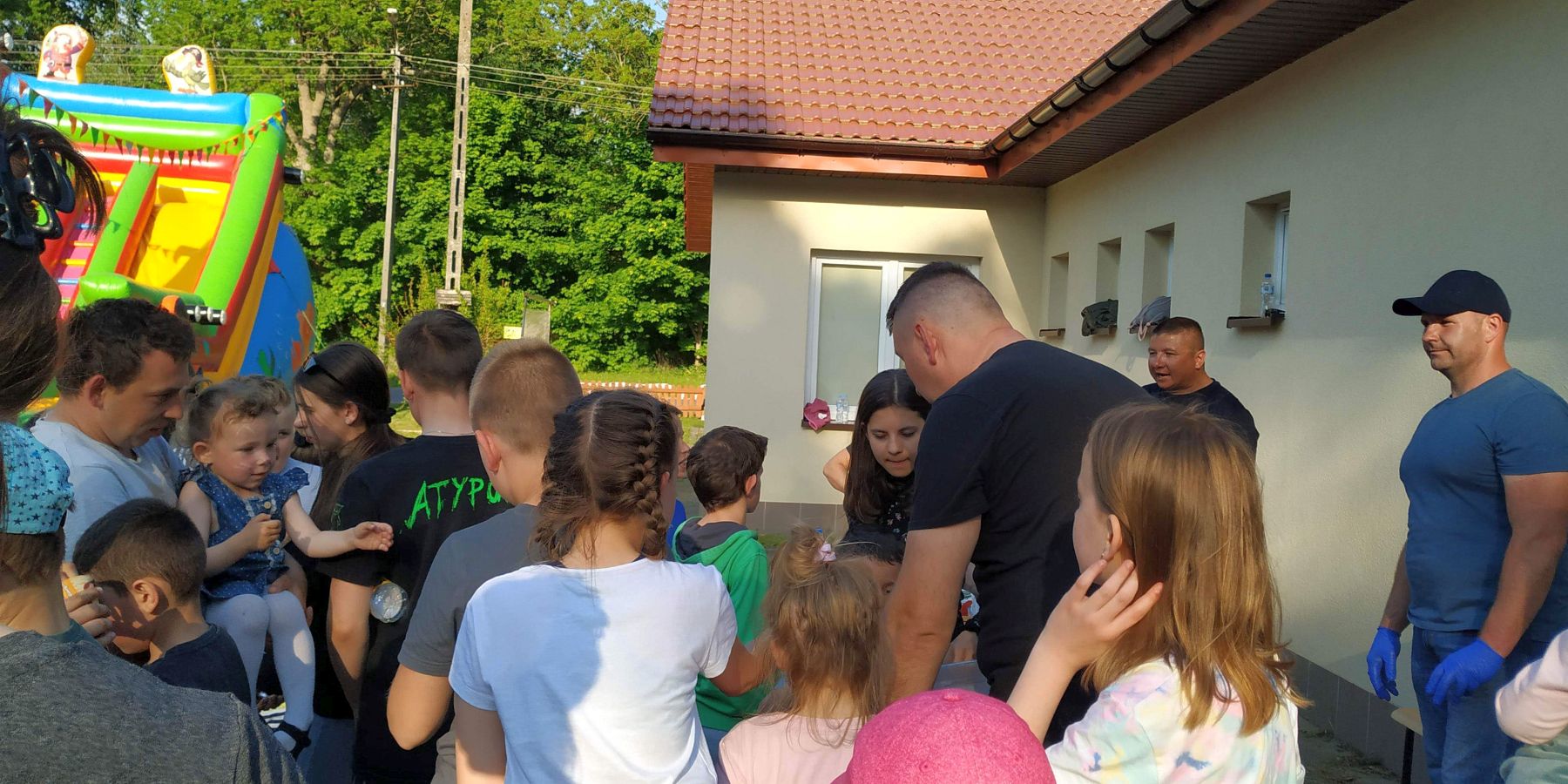 Dzieci i dorośli przed Domem Wiejskim w Gorzycy podczas obchodów Dnia Dziecka.