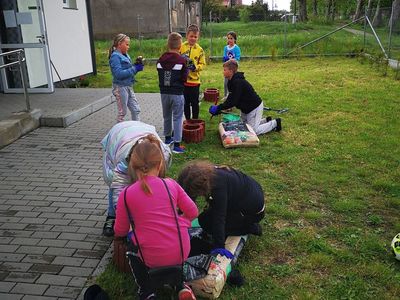 Dzieci z Placówki Wsparcia Dziennego w Kusicach dosypujące ziemię do gazonów.