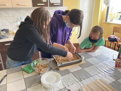 Dzieci z Placówki Wsparcia Dziennego w Święcianowie wykładają owsianą kruszonkę na wierzch ciasta.