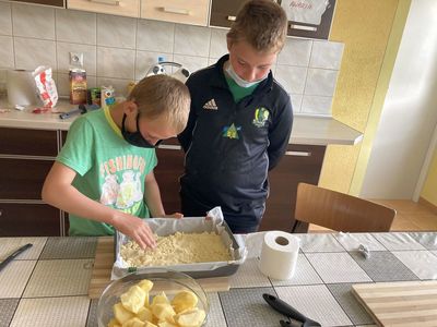 Chłopcy z Placówki Wsparcia Dziennego w Święcianowie w trakcie wylepiania kruchym ciastem blaszki do pieczenia.