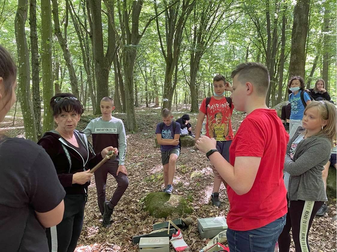 Nauczycielka Marta Perzyńska z uczniami ze Szkoły Podstawowej im. Noblistów Polskich w Niemicy w czasie opowieści o życiu i obrzędach społeczności pochodzącej z neolitu