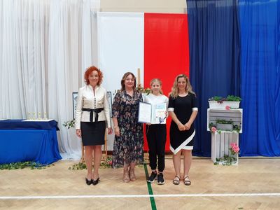 Wychowawca ósmej klasy, dyrektor szkoły, wyróżniona uczennica z mamą. 
