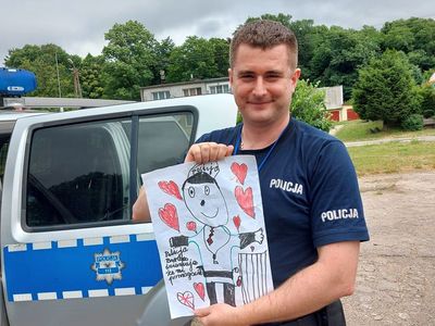 Policjant z podziękowaniem wręczonym przez podopiecznych z Placówki Wsparcia Dziennego w Laskach.