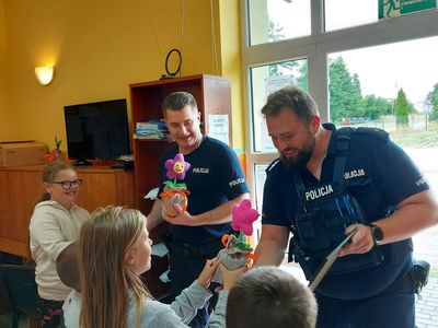 Dzieci z Placówki Wsparcia Dziennego w Laskach w trakcie wręczania podziękowania oraz własnych prac policjantom. 