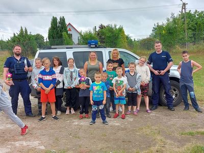 Pamiatkowe zdjęcie ze spotkania, - dwaj policjanci, wychowawczynie i dzieci z PWD Laski. 
