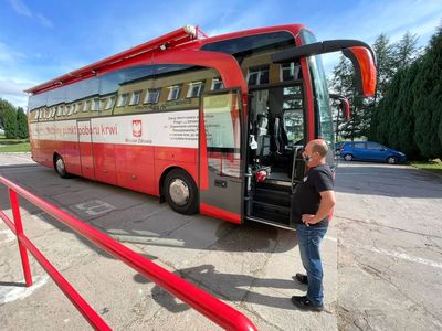 Krwiobus przed Świetlicą Kultury w Malechowie oraz osoba przed wejściem do pojazdu na pierwszym planie.
