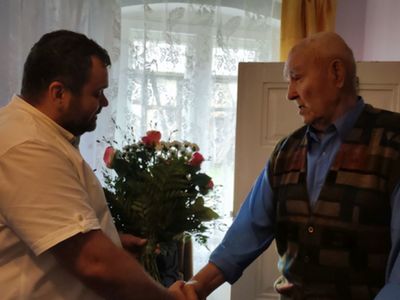 Wójt Radosław Nowakowski wręcza kwiaty 90-letniemu Józefowi Paradiukowi z Malechówka.