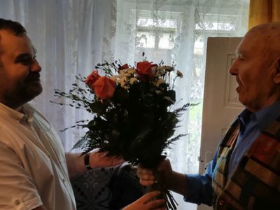 Wójt Radosław Nowakowski wręcza kwiaty 90-letniemu Józefowi Paradiukowi z Malechówka. 