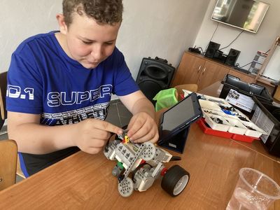 Chłopiec z Placówki Wsparcia Dziennego w Święcianowie w trakcie konstruowania robota Lego Mindstorm.