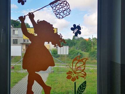 Dziewczynka z Placówki Wsparcia Dziennego w Kusicach łapiąca kolorowe motyle.