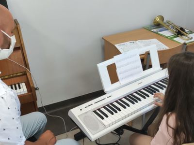 Instruktor Robert Słobodzian i uczennica podczas próby gry na keyboardzie.