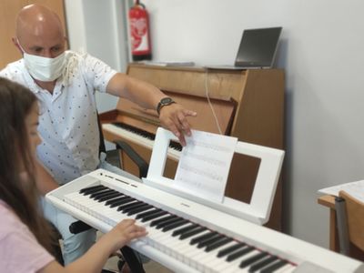 Instruktor Robert Słobodzian i uczennica podczas próby gry na keyboardzie. 