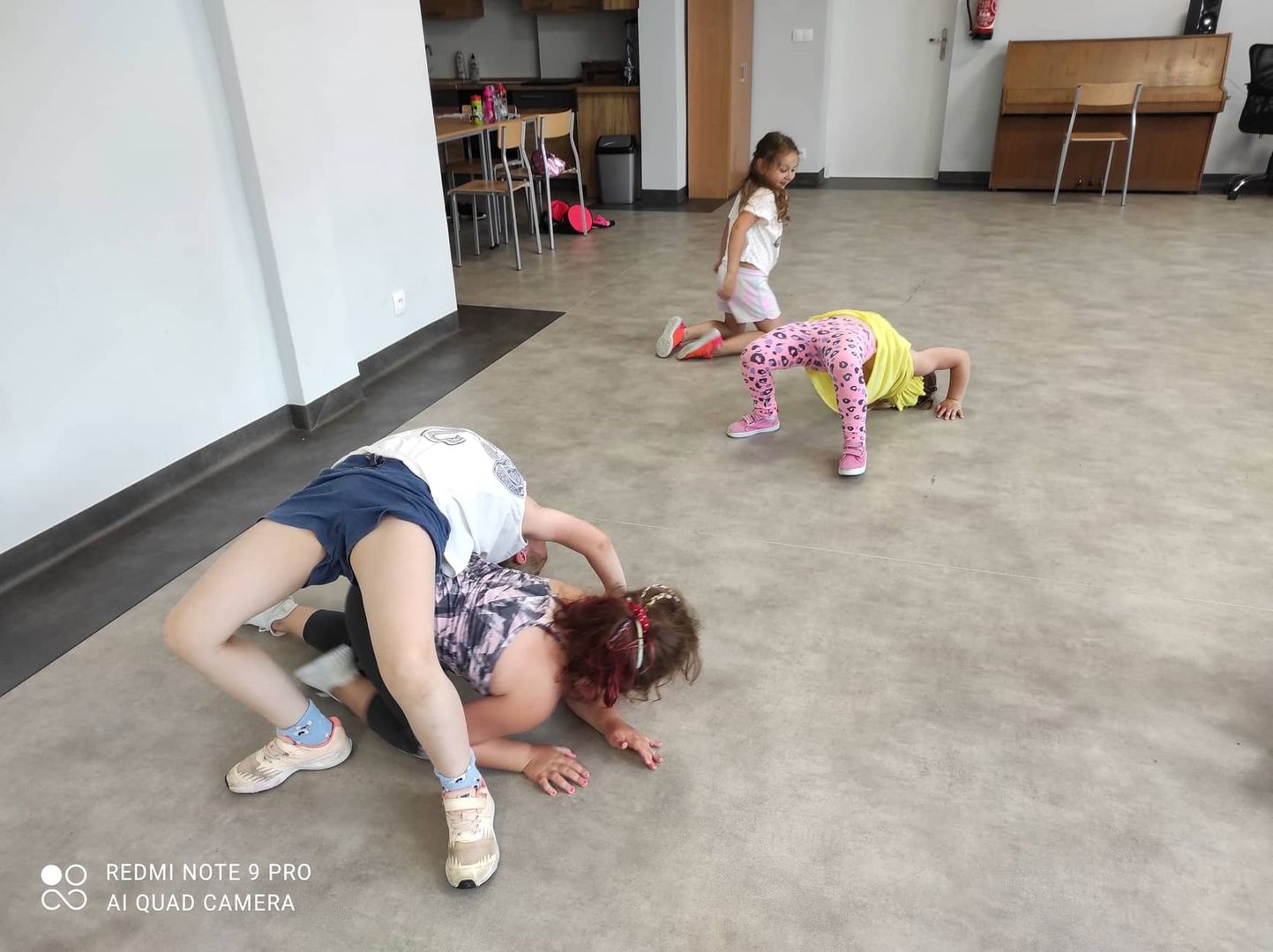 Dzieci z grupy breakdance ćwiczą mostek w sali świetlicy kultury w Malechowie.