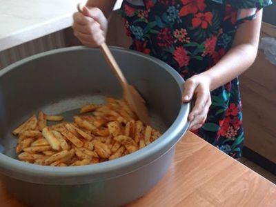 Dziewczynka  z Placówki Wsparcia Dziennego w Kosierzewie podczas łączenia frytek z przeprawami.
