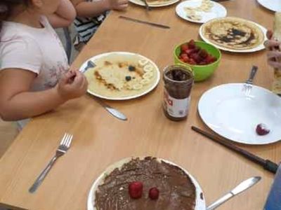 Trzy dziewczynki ozdabiają naleśniki według uznania. 