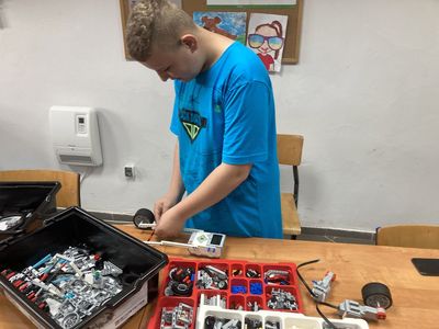 Chłopiec z Placówki Wsparcia Dziennego w Święcianowie w trakcie konstruowania robota Lego Mindstorms.