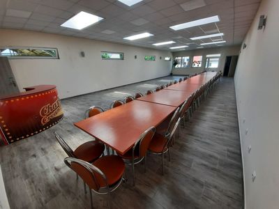 Sala główna świetlicy wiejskiej w Niemicy po remoncie, stół i krzesła, po lewej stronie barek. 