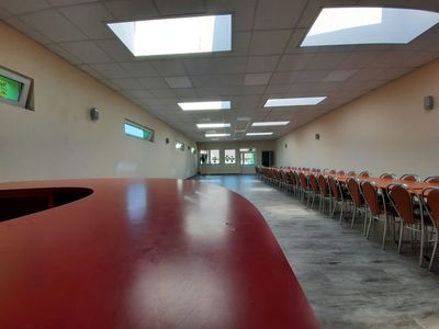 Sala główna świetlicy wiejskiej w Niemicy po remoncie, stół i krzesła, z przodu blat barku. 